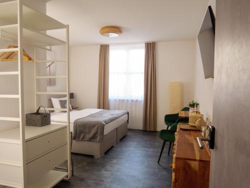 灵斯海姆Hotel Sleep & Dream Nähe Europa Park und Rulantica的一间卧室配有一张床、梳妆台和书桌
