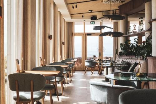 奥弗芬Boutique Hotel Blendin Bloemendaal aan Zee的餐厅里一排桌椅