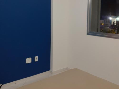 皮乌马Apartamento 101 com vista da piscina e mar的一间设有蓝色墙壁和窗户的客房