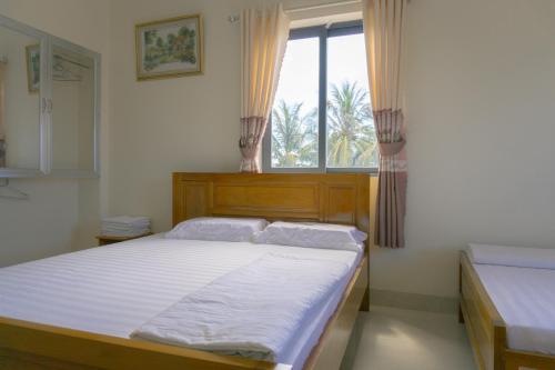 Phú QuýKhách Sạn An Bình Đảo Phú Quý的一间卧室设有一张大床和一个窗户。