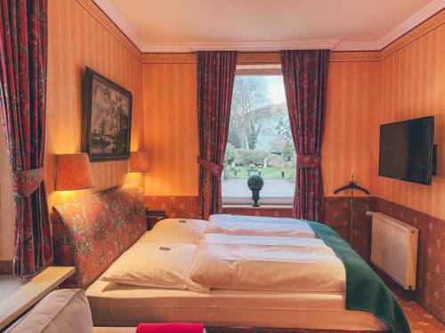 汉堡米特尔维格酒店的一间卧室设有一张大床和一个窗户。