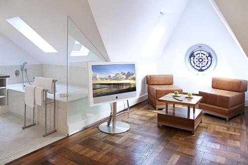 科隆豪博圣约瑟夫酒店的客厅配有电视、沙发和椅子