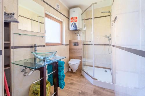 德布吉Milagro Baltico的一间带玻璃水槽和淋浴的浴室