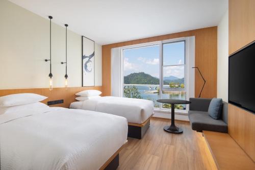 淳安杭州千岛湖万枫酒店­­的酒店客房设有两张床和一台平面电视。