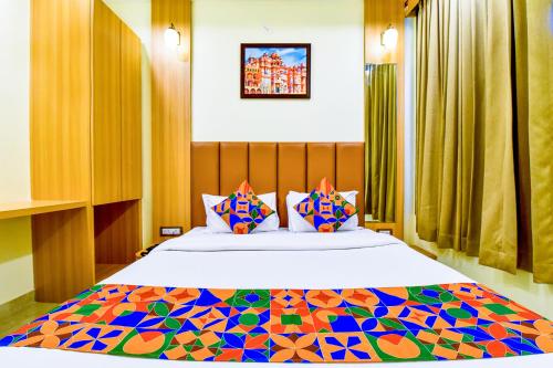 乌代浦FabExpress Mewar Shine的一间卧室配有一张带色彩缤纷枕头的大床