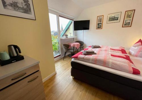 什未林北极酒店的一间卧室配有一张床、一张书桌和一个窗户。