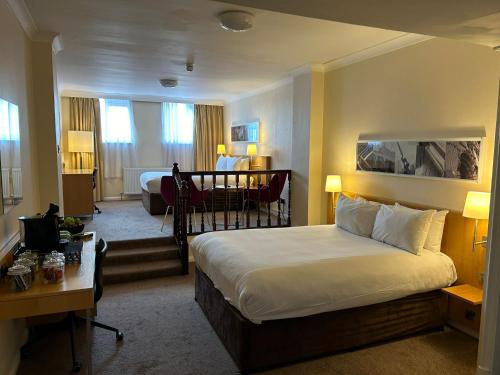 曼彻斯特曼彻斯特市中心大不列颠酒店的配有一张床和一张书桌的酒店客房