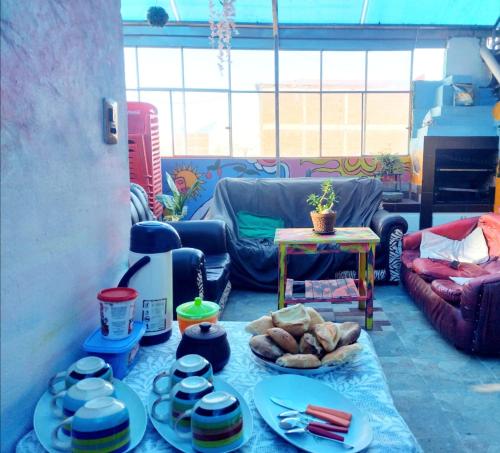 奥鲁罗Backpacker Oruro的客厅配有带盘子和碗的桌子