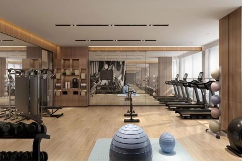 Shenzhen深圳宝安万枫酒店的健身房设有一排跑步机和健身器材