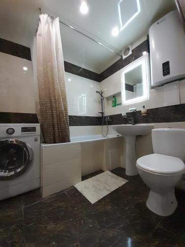 哈尔科夫Apartments Новые дома Масельского Хтз的浴室配有卫生间、盥洗盆和洗衣机。