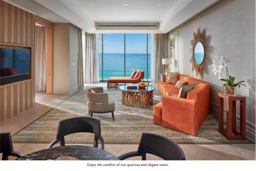 迪拜Mandarin Oriental Jumeira, Dubai的客厅配有橙色家具,享有海景。