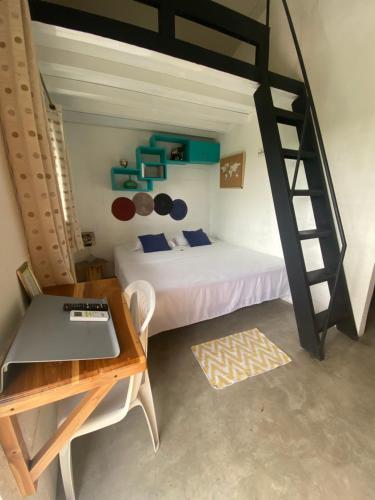 圣卡洛斯A Piece of Paradise的一间卧室配有一张床、一张桌子和一张双层床。
