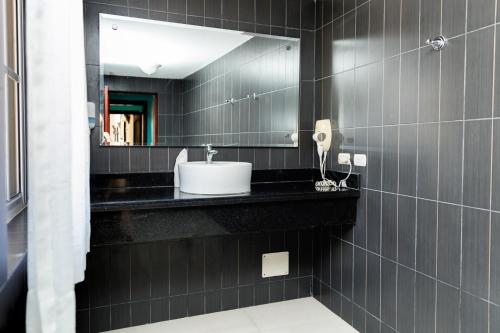 蓬塔卡纳Hotel Brisa的黑色浴室设有水槽和镜子