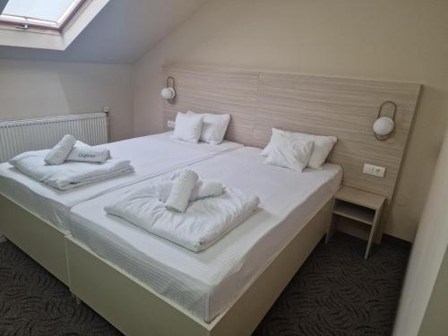 贝尤什Motel LAGUNA的卧室配有一张带两个枕头的大白色床