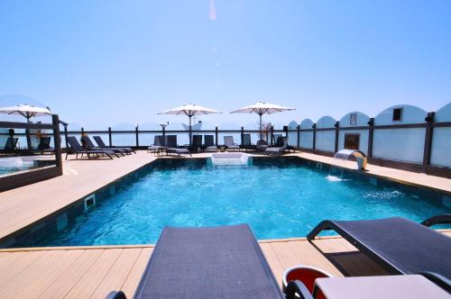 伊斯坦布尔维琴察酒店的一座大楼内的游泳池,配有椅子和遮阳伞