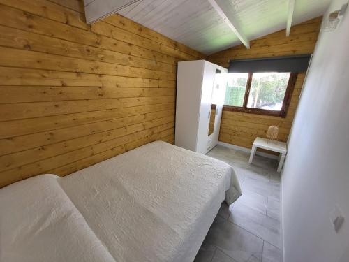 吉亚德伊索拉Preciosa cabaña的木制客房内的一间卧室,配有一张床