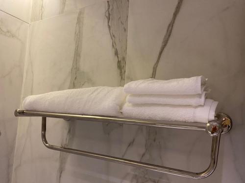 艾卜哈Jardin an的浴室内毛巾架和白色毛巾