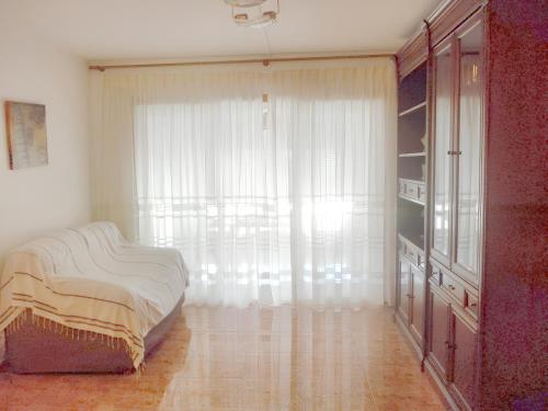 圣卡洛斯拉腊皮塔3 bedrooms apartement at Sant Carles de la Rapita 200 m away from the beach with sea view furnished terrace and wifi的一间卧室设有一张床和一个大窗户