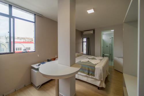 若昂佩索阿Lagoa Park Hotel的一间卧室配有床和水槽,还有一间浴室