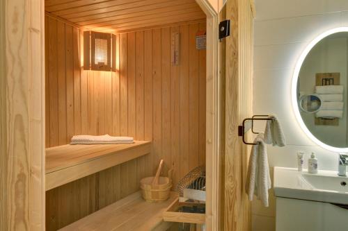 蒙特朗布朗Les Eaux 207-2 Mountain adventure的浴室设有1个带水槽和镜子的桑拿浴室