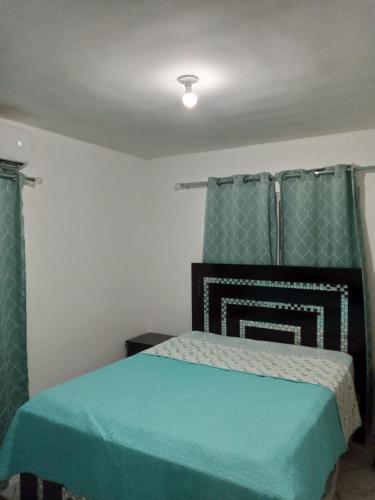 LiceyApartamento Amublado con piscina的一间卧室配有一张带蓝色棉被的床