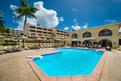 辛普森湾Simpson Bay Resort Marina & Spa的度假酒店的游泳池配有椅子和遮阳伞