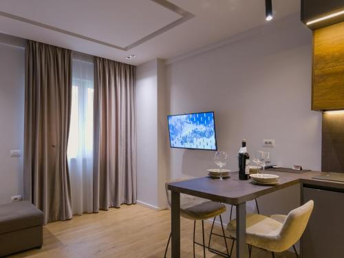 地拉那PIN Apartments的客厅配有桌椅和电视。