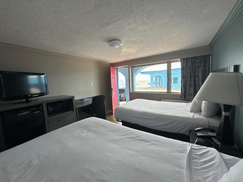 加尔维斯敦Econo Lodge Galveston Seawall的酒店客房设有两张床和一台平面电视。
