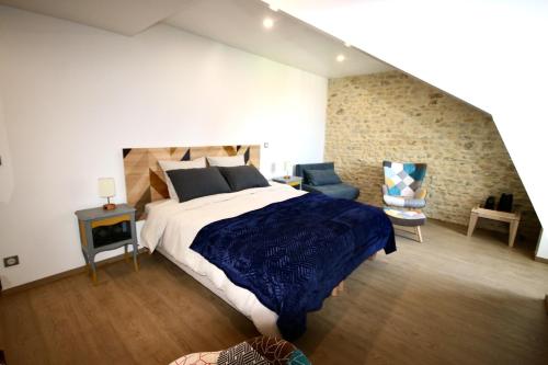 特雷西索梅La Villa Mirabelle 2min d'Arromanches-les-Bains的一间卧室配有一张特大号床和蓝毯