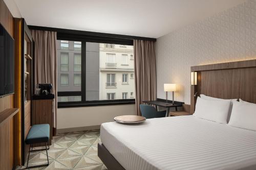 伊西莱穆利诺Courtyard by Marriott Paris Porte de Versailles的酒店客房设有一张床和一个大窗户