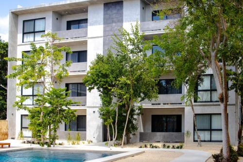 图卢姆Hotel Casa Tortuga Tulum - Cenotes Park Inclusive的公寓大楼前方设有游泳池