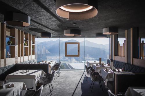 瓦尔道拉阿尔品胡贝图斯全景酒店的餐厅设有桌椅和大窗户。