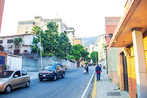 加拉加斯Apartamento Av Andres Bello的一条城市街道,有汽车,有人沿着街道走