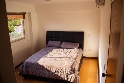 加拉加斯Apartamento Av Andres Bello的一间小卧室,配有一张带黑色床头板的床