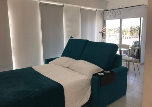 罗萨里奥Estudio en Puerto Norte con PILETA incluida y COCHERA opcional的一间卧室配有一张蓝色床头板的床