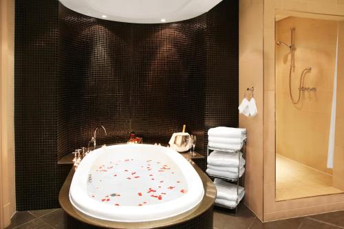 坎帕拉Sheraton Kampala Hotel的浴室配有带鲜花的浴缸。