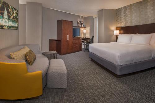 华盛顿华盛顿哥伦比亚特区/美国国会大厦万怡酒店的酒店客房配有床、沙发和椅子