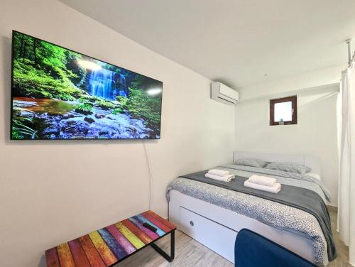 赛斯韦泰Cozy Room w A/C, 65'' TV & Floor Heating的卧室配有一张床铺,墙上配有电视