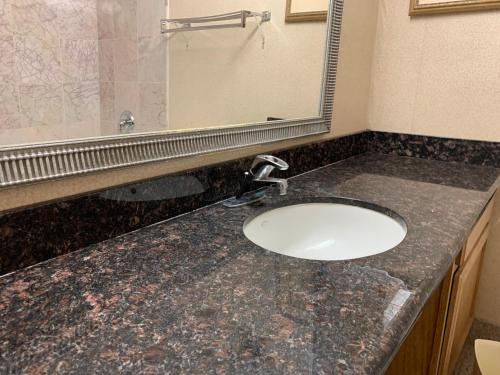 卡斯珀Riverside Hotel的浴室的柜台设有水槽和镜子