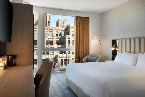 纽约纽约曼哈顿/苏活区万怡酒店的酒店客房设有一张床和一个大窗户