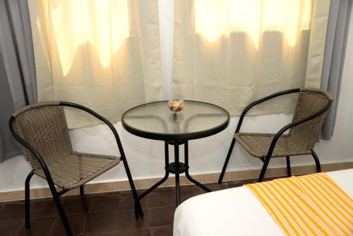 圣多明各Hostal Mi Rincón的房间里的两张椅子和一张玻璃桌
