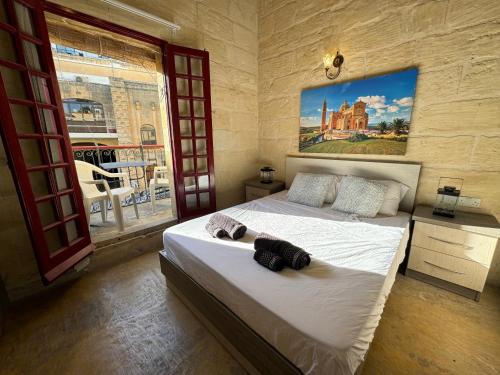 Għajn il-KbiraThe Nest 148 Townhouse的一间卧室设有两张床,墙上挂着一幅画