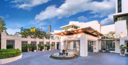 曼谷曼谷暹罗凯宾斯基饭店 - SHA Extra Plus Certified的一座白色的大建筑,庭院里设有一个喷泉