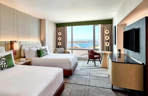 圣地亚哥奥米尼圣迭戈酒店的酒店客房设有两张床和电视。