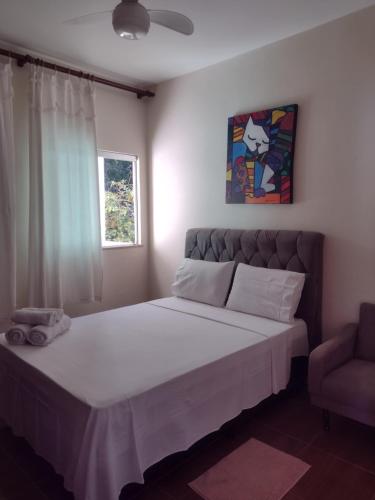 圣若昂-德雷Aconchego Mineiro的一间卧室配有一张大床和一把椅子