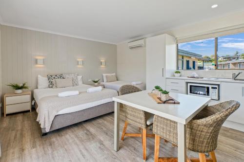 梅林布拉Tasman Holiday Parks - Merimbula的一间卧室配有一张床和一张桌子及椅子