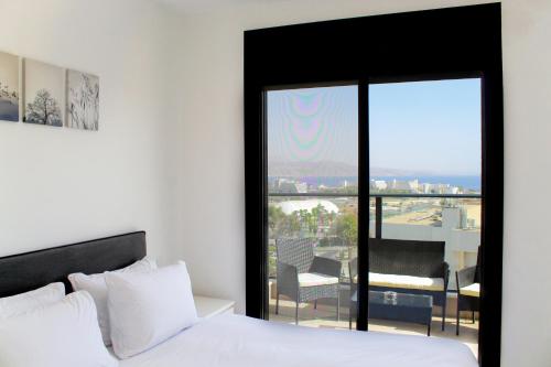 埃拉特Suite Apartment With Sea View #55 By Hashdera Eilat的一间卧室设有一张床,享有阳台的景色