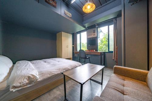 Dalin新橙居的一间卧室配有一张床、一张桌子和一张沙发