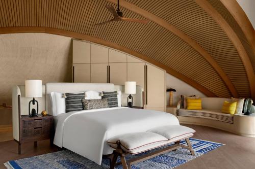 ḨanakNujuma, a Ritz-Carlton Reserve的卧室配有一张白色的大床和一张沙发。