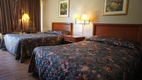 橙县Executive Inn & Suites的酒店客房设有两张床和两盏灯。